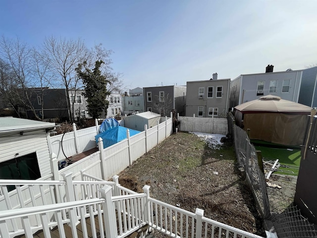 view of yard featuring a gazebo, a fenced backyard, and a residential view