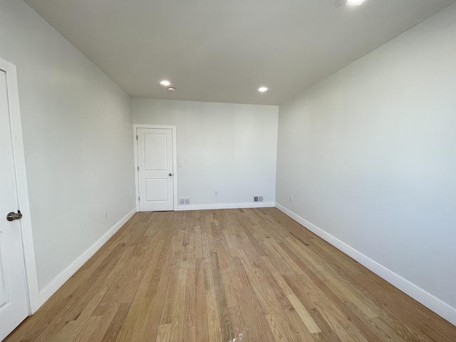 spare room featuring light wood-type flooring, visible vents, baseboards, and recessed lighting