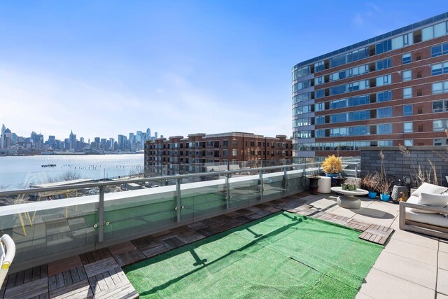 exterior space with a balcony, a water view, and a city view