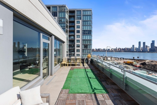 balcony featuring a water view and a city view