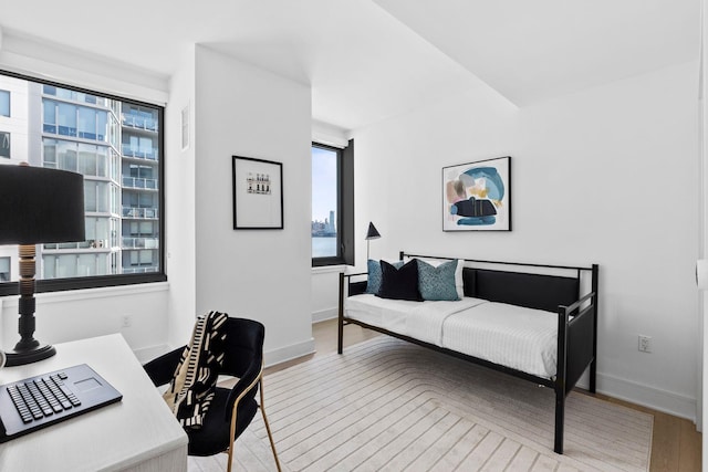 bedroom with wood finished floors and baseboards