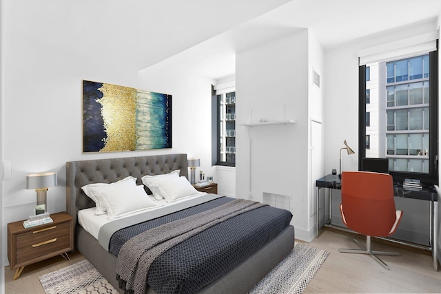 bedroom featuring visible vents and wood finished floors