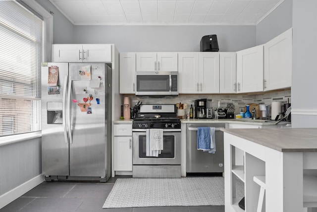 57 Booraem Ave, Jersey City, NJ 07307 - kitchen featuring appliances with stainless steel finishes, light countertops, decorative backsplash, white cabinetry, and light tile patterned flooring