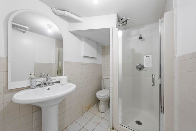 57 Booraem Ave, Jersey City, NJ 07307 - bathroom featuring tile walls, a shower stall, tile patterned flooring, and a wainscoted wall