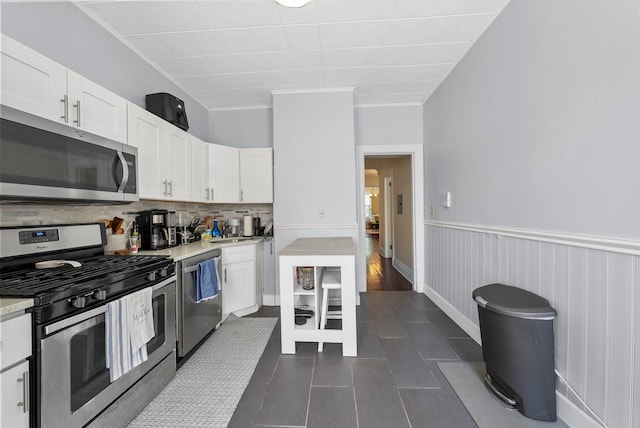 57 Booraem Ave, Jersey City, NJ 07307 - kitchen featuring appliances with stainless steel finishes, white cabinetry, light countertops, decorative backsplash, and a wainscoted wall