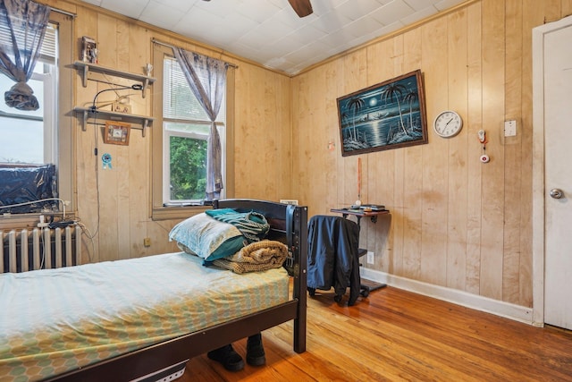 442 Avenue E Ave E, Bayonne, NJ 07002 - bedroom featuring wooden walls, wood finished floors, baseboards, radiator heating unit, and a ceiling fan
