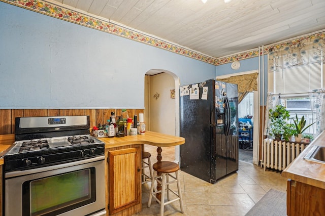 442 Avenue E Ave E, Bayonne, NJ 07002 - kitchen with stainless steel range with gas stovetop, black fridge, arched walkways, brown cabinetry, and wooden ceiling