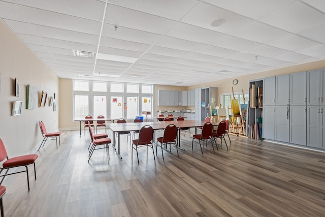 dining space with a paneled ceiling, visible vents, and wood finished floors