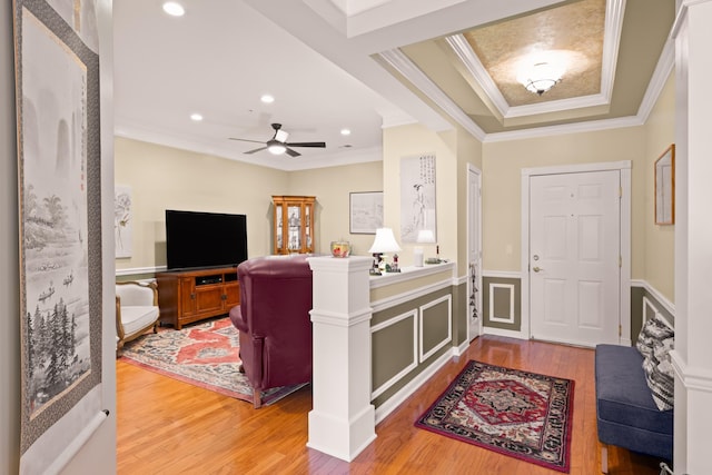 entrance foyer featuring ornamental molding, light wood-style flooring, and a ceiling fan