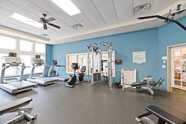 workout area with a paneled ceiling, visible vents, and a healthy amount of sunlight