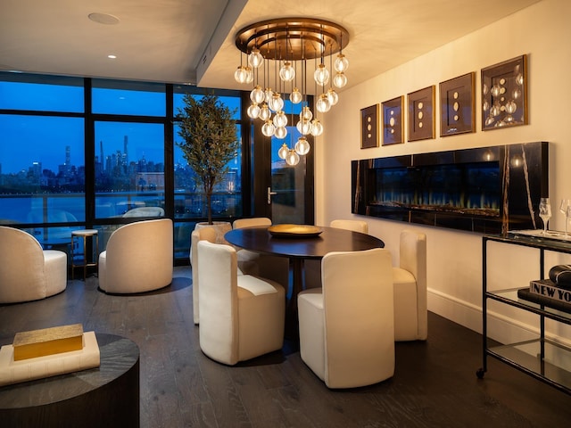 dining room featuring hardwood / wood-style floors, floor to ceiling windows, a fireplace, and a chandelier