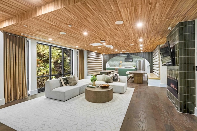 living room featuring wooden ceiling, dark wood-type flooring, and log walls