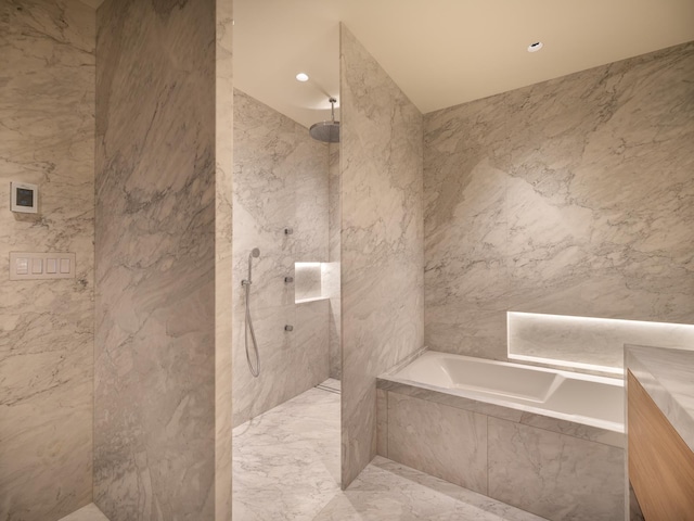 bathroom with separate shower and tub, vanity, and tile walls