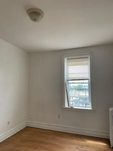 unfurnished room featuring wood finished floors and baseboards