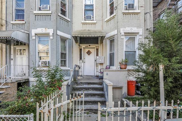 property entrance featuring fence and brick siding