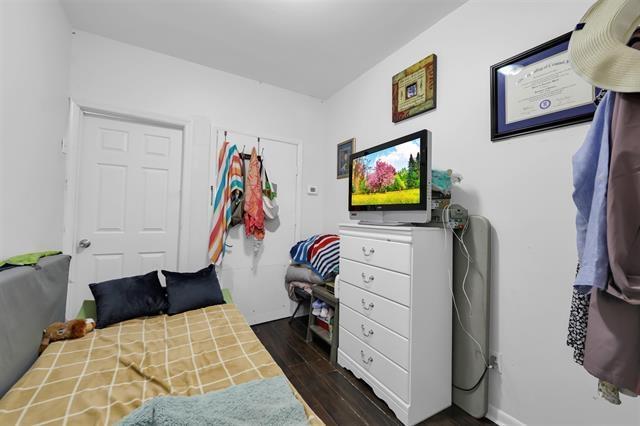 bedroom with dark wood-style flooring