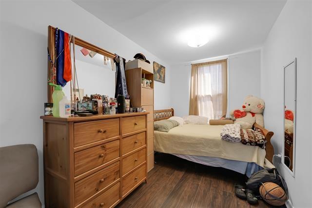 bedroom with dark wood-type flooring