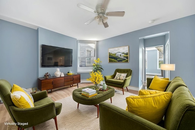 living room featuring ceiling fan and light hardwood / wood-style flooring