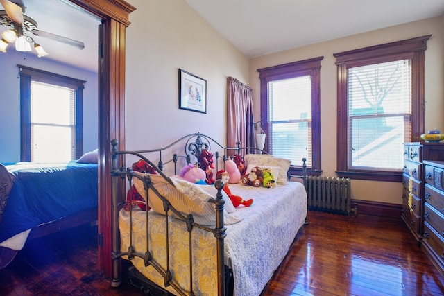 bedroom featuring radiator heating unit and dark hardwood / wood-style floors