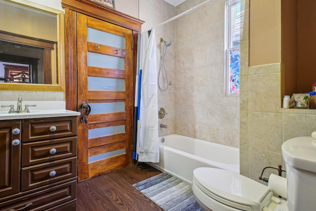 full bathroom featuring wood-type flooring, tile walls, vanity, toilet, and shower / tub combo with curtain