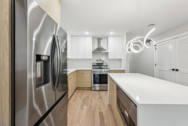 27 E 16th St, Bayonne, NJ 07002 - kitchen featuring stainless steel appliances, wall chimney exhaust hood, modern cabinets, light wood-type flooring, and recessed lighting