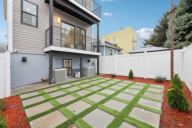 27 E 16th St, Bayonne, NJ 07002 - rear view of property featuring cooling unit, a balcony, a patio, and a fenced backyard
