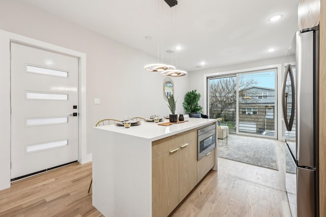 27 E 16th St, Bayonne, NJ 07002 - kitchen with stainless steel appliances, a center island, light wood finished floors, modern cabinets, and light countertops