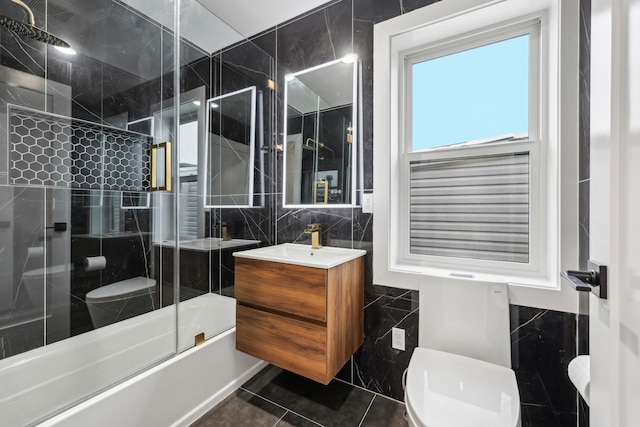 27 E 16th St, Bayonne, NJ 07002 - full bathroom with tile walls, toilet, vanity, and bath / shower combo with glass door