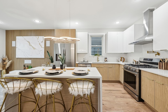 27 E 16th St, Bayonne, NJ 07002 - kitchen with stainless steel appliances, a sink, wall chimney exhaust hood, a kitchen bar, and light countertops