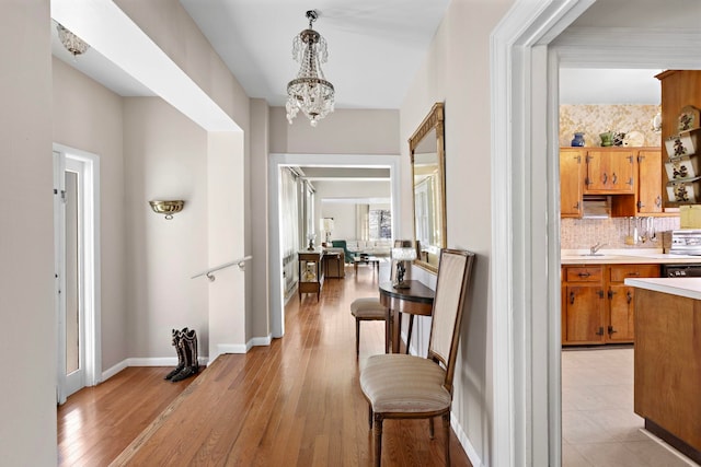 6 Kingswood Rd, Weehawken, NJ 07086 - hall with a chandelier, a sink, light wood finished floors, and baseboards
