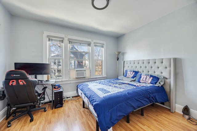 bedroom featuring cooling unit, wood finished floors, and baseboards