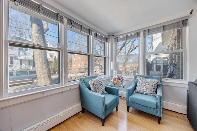 sunroom featuring plenty of natural light and a baseboard radiator