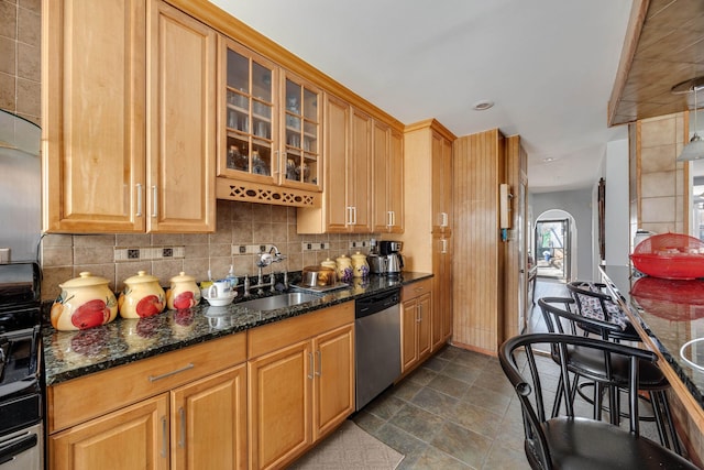 kitchen with arched walkways, a sink, glass insert cabinets, dishwasher, and backsplash