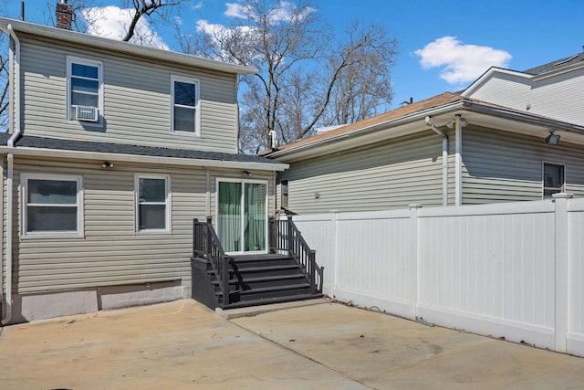 rear view of house with a patio area, fence, and a chimney