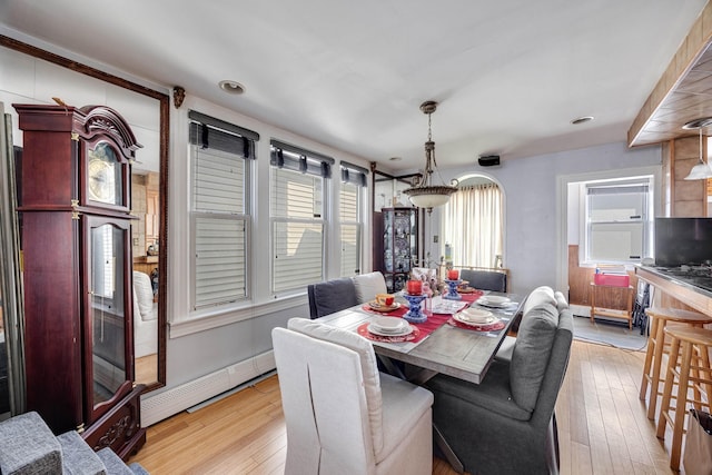 dining room with a baseboard heating unit, light wood-type flooring, and baseboard heating