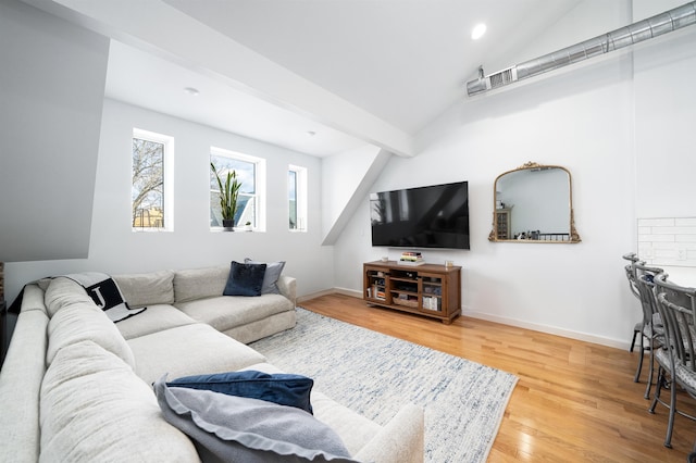 living room featuring hardwood / wood-style flooring and vaulted ceiling