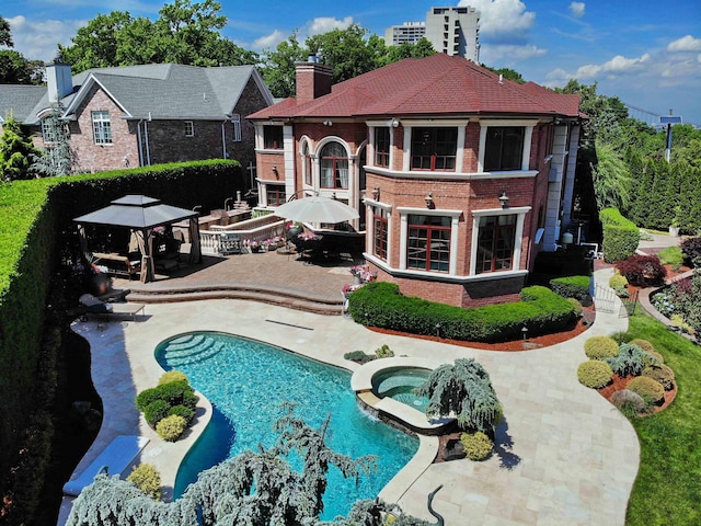 2 Euclid Rd, Fort Lee, NJ 07024 - back of house with a gazebo, brick siding, a pool with connected hot tub, a patio area, and a chimney