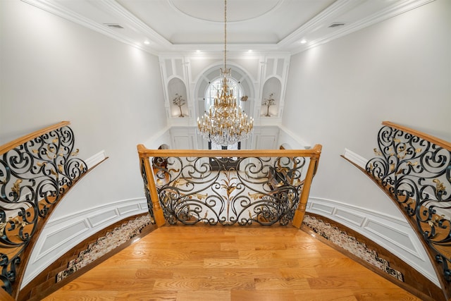 2 Euclid Rd, Fort Lee, NJ 07024 - staircase featuring a chandelier, wood finished floors, a decorative wall, a raised ceiling, and ornamental molding