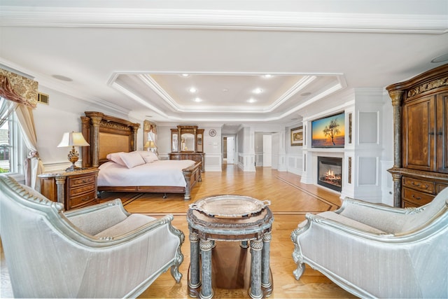 2 Euclid Rd, Fort Lee, NJ 07024 - bedroom with crown molding, a decorative wall, a glass covered fireplace, a tray ceiling, and light wood-type flooring