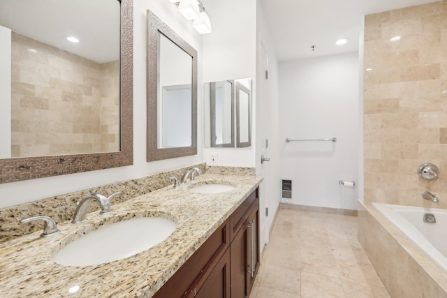 full bathroom featuring tiled tub, a sink, tile patterned flooring, and heating unit