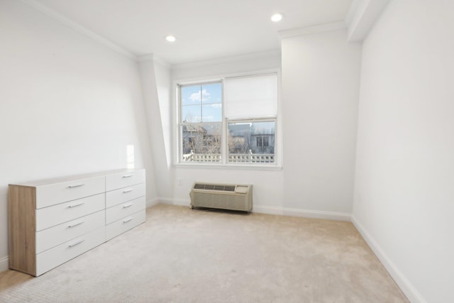 unfurnished bedroom with carpet, a wall unit AC, crown molding, recessed lighting, and baseboards