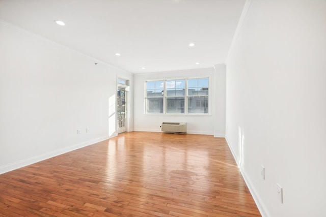 empty room with ornamental molding, recessed lighting, light wood-style flooring, and baseboards