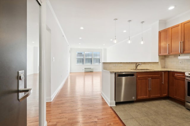 kitchen featuring brown cabinets, stainless steel appliances, light wood-style flooring, decorative backsplash, and a sink