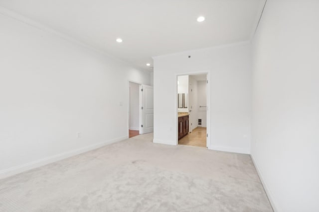 unfurnished bedroom with baseboards, crown molding, and light colored carpet