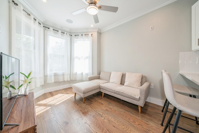 living room with light hardwood / wood-style floors, ceiling fan, and ornamental molding