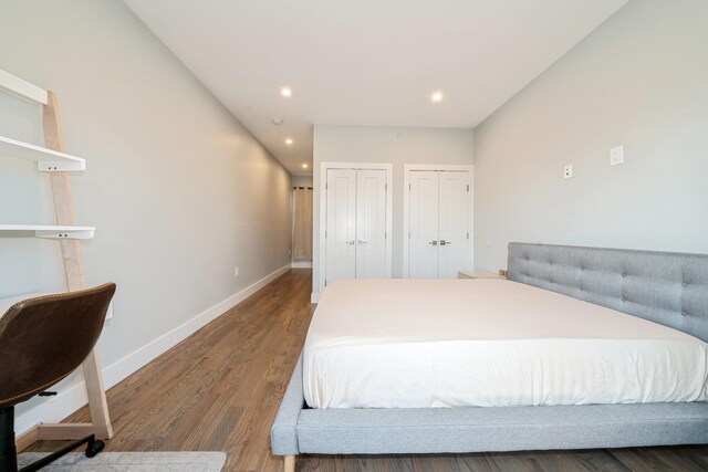 bedroom featuring hardwood / wood-style floors and two closets