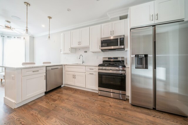 kitchen featuring dark wood-type flooring, white cabinetry, hanging light fixtures, and stainless steel appliances