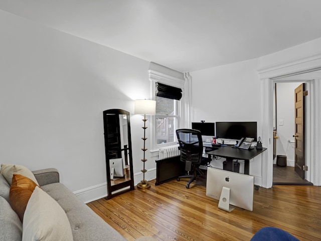 home office with baseboards and wood finished floors