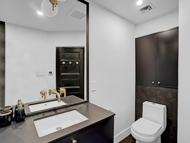 bathroom with toilet, vanity, visible vents, and tile patterned floors