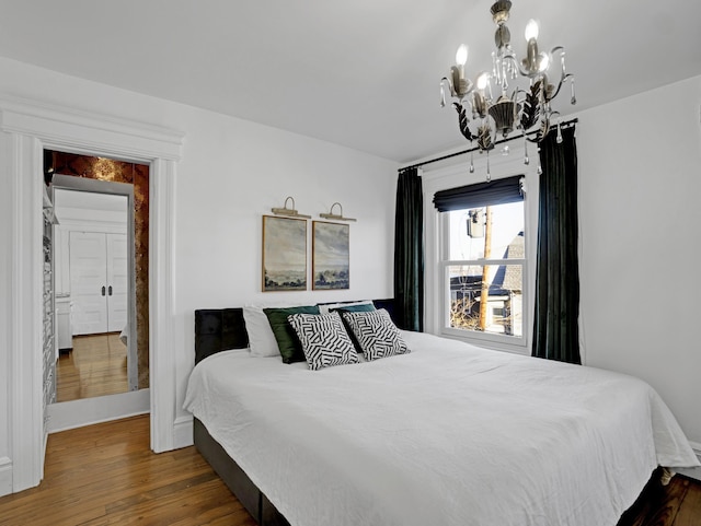 bedroom with dark wood-type flooring and a notable chandelier